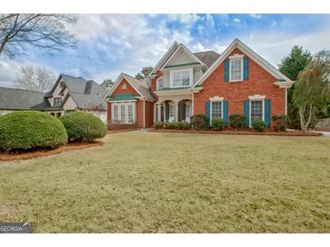 Charming two-story brick home with manicured lawn, classic architectural details, and complementary shutters at 2510 Shoreline Pkwy, Villa Rica, GA 30180