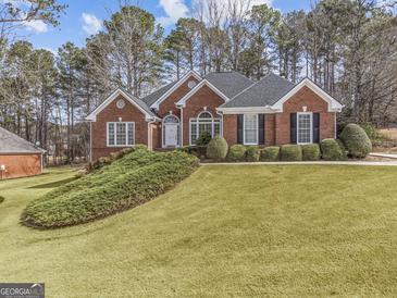 Charming brick home featuring a well-manicured lawn and mature landscaping, creating inviting curb appeal at 807 Ivy Ridge Dr, Loganville, GA 30052