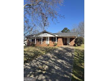 Charming brick ranch-style home with mature trees and a long driveway at 220 Cabriolet Trl, Mcdonough, GA 30253