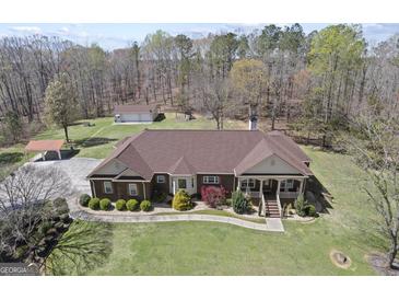 Stunning brick home features a sprawling lawn, covered parking, and a detached garage at 7395 Old Rico Rd., Chattahoochee Hills, GA 30268