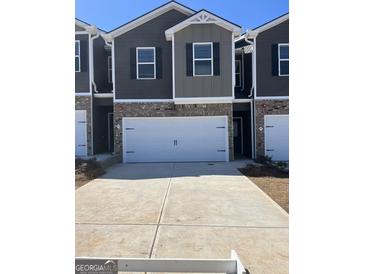 Attractive townhome featuring a two-car garage and brick and siding exterior in a desirable neighborhood at 11523 Kimberly Way # 6, Hampton, GA 30228