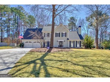 Traditional two-story home featuring a manicured lawn, two-car garage, and charming facade with black shutters at 339 Kensington Dr, Peachtree City, GA 30269