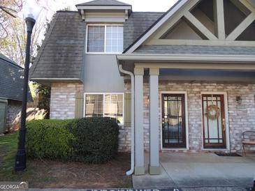 Charming brick townhouse with covered entrance, well-maintained landscaping, and inviting front door at 117 Rondak Se Cir, Smyrna, GA 30080