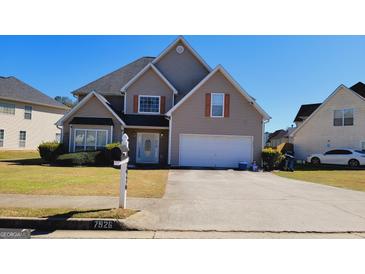 Charming two-story home with a well-manicured lawn and attached two-car garage, perfect for Gathering living at 7926 Palomino Pass, Riverdale, GA 30274