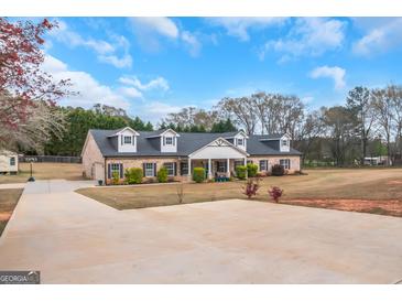 Sprawling single-story home with manicured lawn and dormer windows under a blue sky at 1500 Highway 155 North, Mcdonough, GA 30252