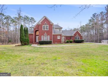 Beautiful brick home featuring manicured lawn and mature trees at 643 Old Greenville Rd, Fayetteville, GA 30215