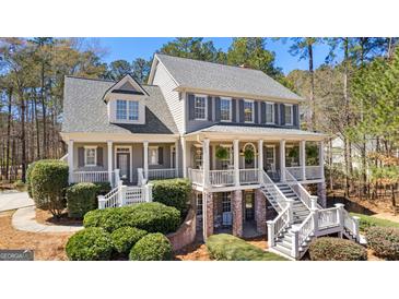 Stately two-story home boasting a welcoming double porch, gray siding, and lush landscaping at 300 Tarragon Dr, Fayetteville, GA 30215