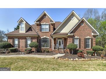Charming brick home with manicured lawn, mature landscaping, and inviting front entrance at 149 Crown Glen Way, Stockbridge, GA 30281