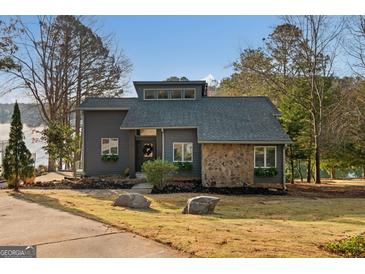 Contemporary home featuring stone accents and a well-manicured front yard with lake views at 1190 Plantation Dr, Villa Rica, GA 30180