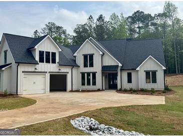 Beautiful modern farmhouse-style home with a three-car garage and a well-manicured lawn at 545 Discovery Lake Dr # 409, Fayetteville, GA 30215