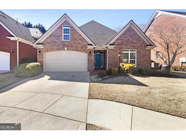 Charming brick home featuring manicured landscaping and a two-car garage at 1832 Glenwood Ln, Snellville, GA 30078