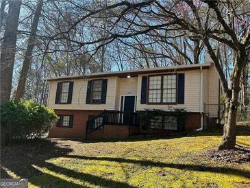 Charming home with light siding, black shutters, and a well-maintained lawn at 6625 Paula Ct, Lithonia, GA 30038