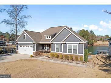 Charming gray home with a well-manicured lawn, attached garage, and beautiful landscaping at 1278 Heritage Dr, Villa Rica, GA 30180