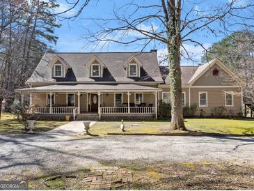 Charming home featuring a welcoming front porch, dormer windows, and gravel driveway at 897 Winding Trl, Lawrenceville, GA 30046