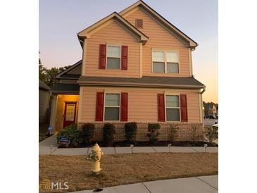 Two-story home with red shutters, tan siding, brick foundation, and a well-maintained front yard at 2478 Oakleaf Rdg, Lithonia, GA 30058