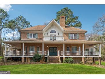 Charming brick home featuring a spacious wrap-around porch and well-maintained lawn at 2200 Gleneagle Nw Ct, Conyers, GA 30012