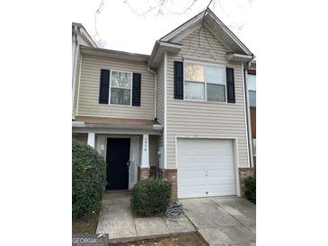 Two-story townhome with a one-car garage, neutral siding, and a well-manicured front yard at 2976 Vining Ridge Ln, Decatur, GA 30034