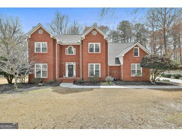 Charming two-story brick home with a well-manicured front yard and classic architectural details at 208 Pinnacle Ct, Peachtree City, GA 30269