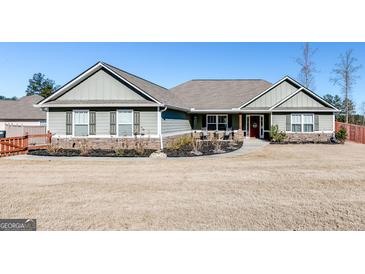Charming single-story home featuring stone accents and manicured landscaping, creating inviting curb appeal at 305 Cranmore Pl, Villa Rica, GA 30180