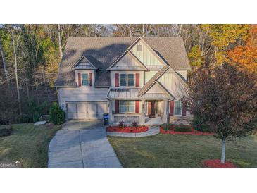 Charming home featuring a two-car garage, red shutters, and landscaped front yard at 5997 Wildcreek Rd, Sugar Hill, GA 30518