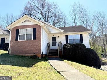 Cozy one-story house featuring vinyl siding, brick accents, manicured landscaping, and charming front entrance at 209 East Wilson St # 25, Villa Rica, GA 30180