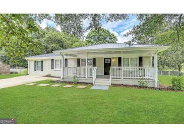 Charming home featuring a well-manicured lawn, inviting front porch, and fresh exterior paint at 245 Carole Dr, Oxford, GA 30054