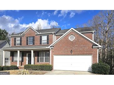 Charming two-story brick home with attached garage and well-maintained landscaping at 7491 Hilltop Way, Atlanta, GA 30349