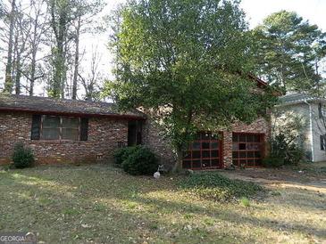 Charming brick home featuring an expansive front yard and attached garage at 3045 Weslock Cir, Decatur, GA 30034