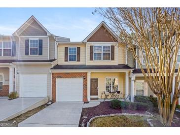 Charming two-story townhome featuring a one-car garage and a well-manicured front yard at 2205 Hyssop Way, Buford, GA 30519