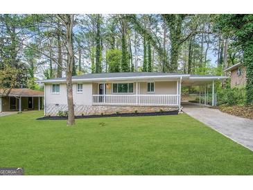 Charming brick home with a covered porch, carport, and well-maintained lawn at 1380 Margarette Dr, Decatur, GA 30035