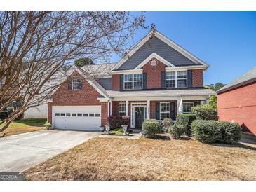 Charming two-story brick home with a well-manicured front yard and attached two-car garage in a quiet neighborhood at 9800 Ivey Ridge Cir, Jonesboro, GA 30238
