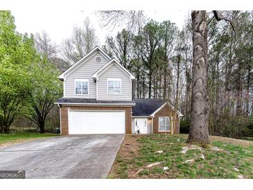 Charming two-story home featuring a brick and gray siding exterior and a two-car garage in a wooded neighborhood at 3821 Rex Mill Sq, Rex, GA 30273