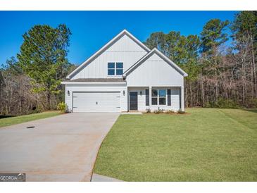 Charming white two-story home with attached garage and freshly landscaped front yard at 105 Creekside Knl, Grantville, GA 30220