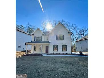 Charming two-story home featuring a welcoming front porch and a well-manicured lawn at 3964 Riverchess Sw Dr # 157, Atlanta, GA 30331