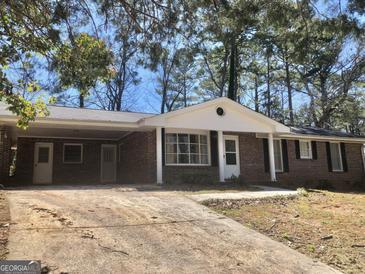 Charming single-story brick home featuring a covered carport and landscaped front yard at 4572 Sahara Sw Dr, Atlanta, GA 30331