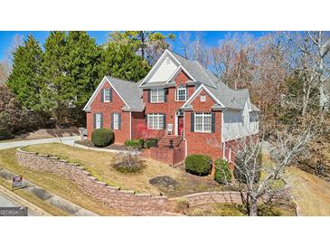 Beautiful two-story brick home featuring manicured landscaping and a charming front porch at 10119 Azalea Dr, Covington, GA 30014