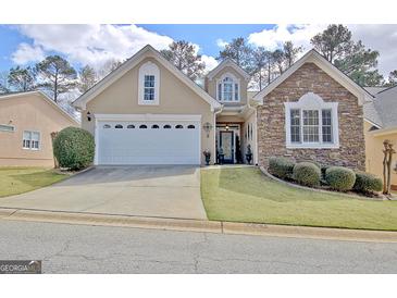 Charming home with a two-car garage and stone and stucco exterior at 221 Collierstown Way, Peachtree City, GA 30269