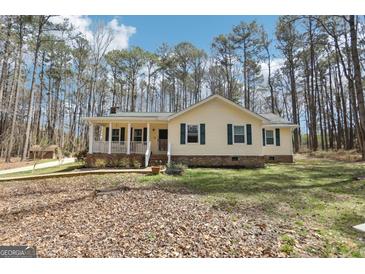 Charming single-story home with a welcoming front porch and a beautifully landscaped yard surrounded by mature trees at 179 Green Valley Rd, Fayetteville, GA 30214