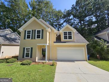 Inviting two-story home with neutral siding, green shutters and a two car garage at 741 S Fairfield Dr, Peachtree City, GA 30269