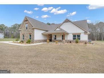 Charming home featuring stone accents, a covered porch, and beautifully landscaped front yard at 196 Old Highway 92, Fayetteville, GA 30215