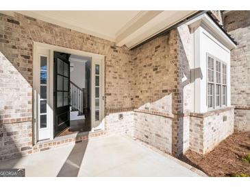 Elegant brick home entrance featuring a black front door with sidelights and staircase view upon entry at 1300 Winfair Ne Ln, Brookhaven, GA 30329