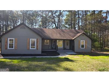 Charming single-story home with natural wood shutters, landscaping, and inviting entrance at 127 Brookwood Estates Trl, Stockbridge, GA 30281