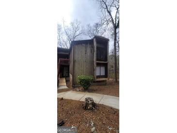 Rustic exterior showcasing aged wood and multiple stories with a weathered sidewalk at 5796 Par Four Ct, Lithonia, GA 30038