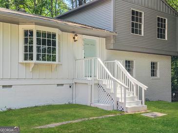 Charming two-story home featuring a bay window, painted brick, and a welcoming light blue front door at 6192 Holiday Blvd, Forest Park, GA 30297