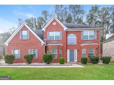 Charming two-story red brick home with a manicured front lawn and gray shutters adding curb appeal at 139 Surge Stone Ln, Stockbridge, GA 30281