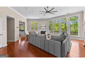 Bright living room boasts hardwood floors, fireplace, large windows, and an open floor plan at 679 Bo Bo Banks Rd, Grantville, GA 30220