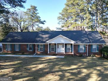 Charming brick home with a manicured lawn and mature trees, offering classic curb appeal and a welcoming entrance at 170 White Rd, Fayetteville, GA 30214