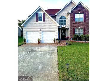 Charming two-story home with a well-manicured lawn, a two-car garage, and a welcoming entrance at 133 Ventura Trl, Stockbridge, GA 30281