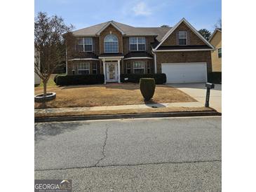 Charming two-story brick home with well-maintained landscaping and a two-car garage, perfect for a Gathering at 7354 Spoleto Loop, Fairburn, GA 30213