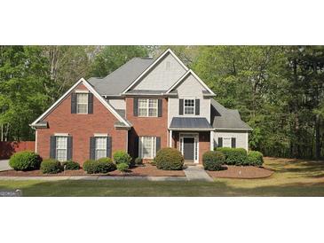 Charming two-story home featuring a brick facade, gray siding, and well-manicured landscaping at 255 Squire Ln, Fayetteville, GA 30214